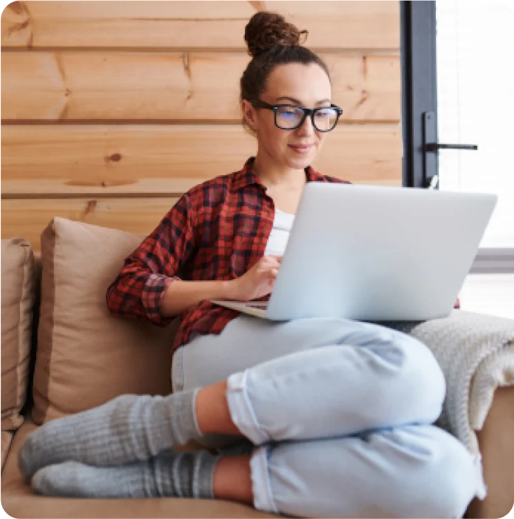 Mulher sentada no sofá com um notebook no colo